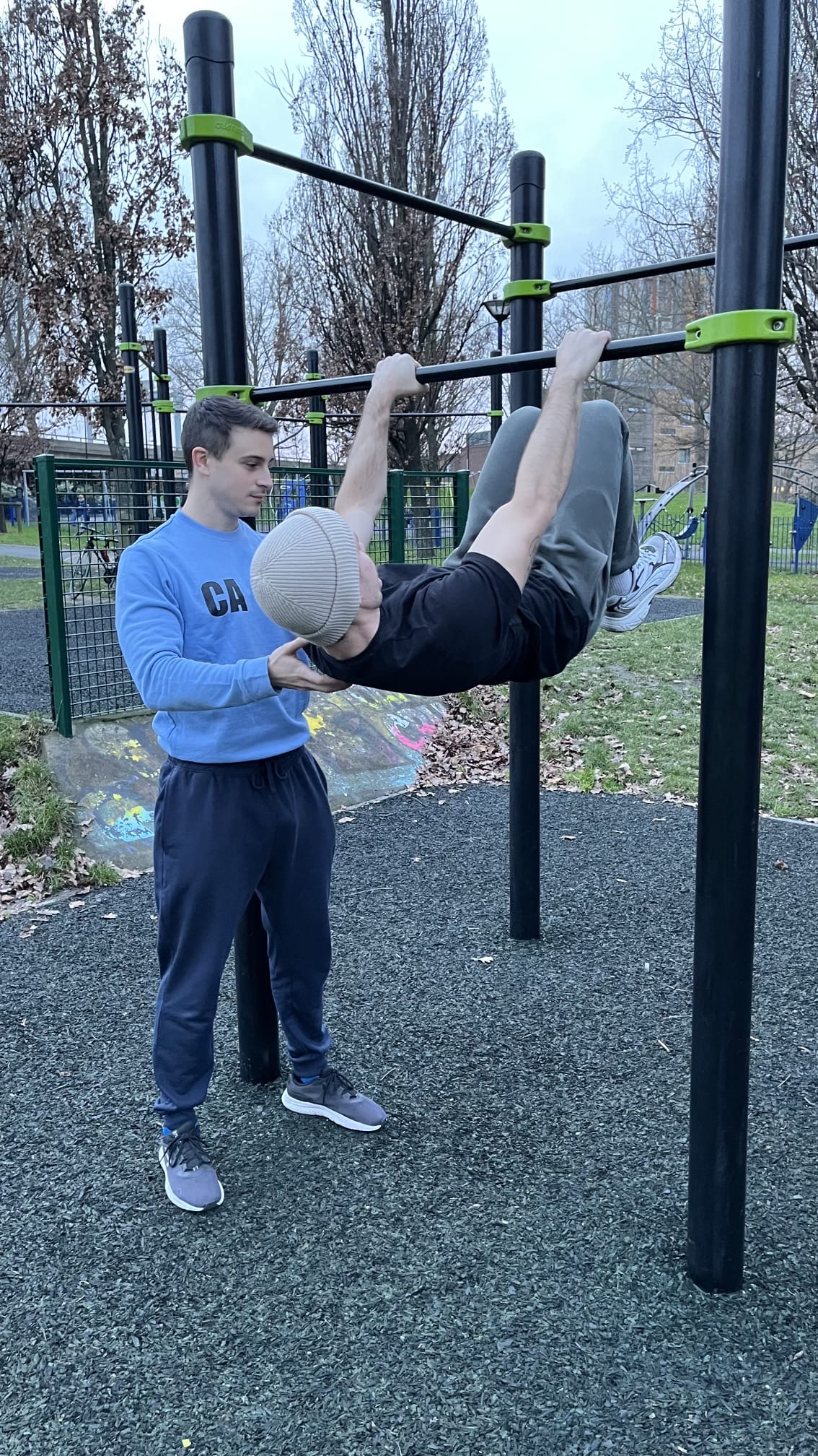 PTatHome personal trainer coaching outdoor calisthenics on bars