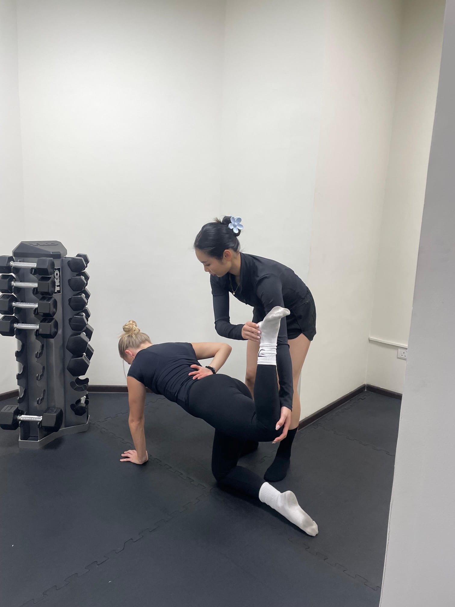 PTatHome personal trainer coaching a client through a Pilates floor exercise